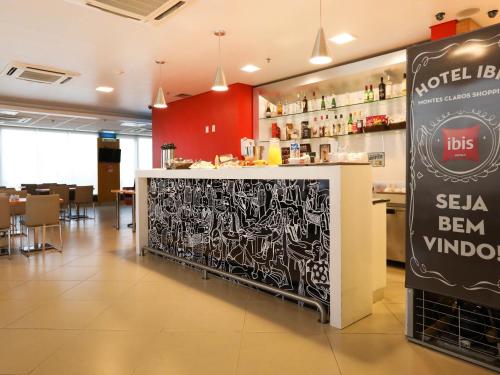 a restaurant with a counter with a sign in it at ibis Montes Claros Shopping in Montes Claros