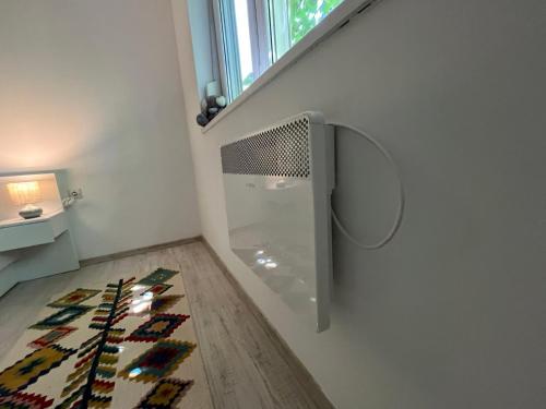 a room with a wall with a window and a rug at Apartman Milica in Vršac