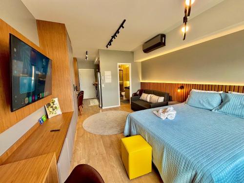 a bedroom with a large bed and a tv at Linked 1001 - Aconchegante e dentro do Shopping in Porto Alegre