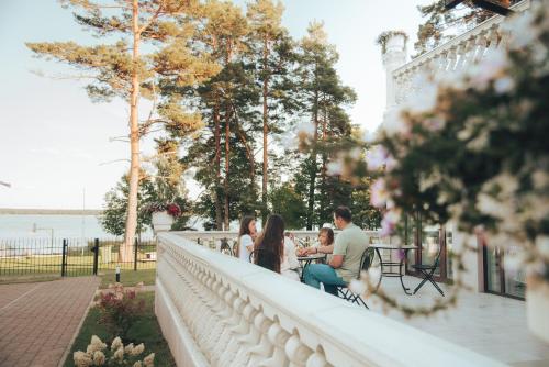 a group of people sitting at a table on a wall at Usmas muiža in Usma