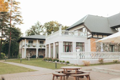 a house with a picnic table in front of it at Usmas muiža in Usma