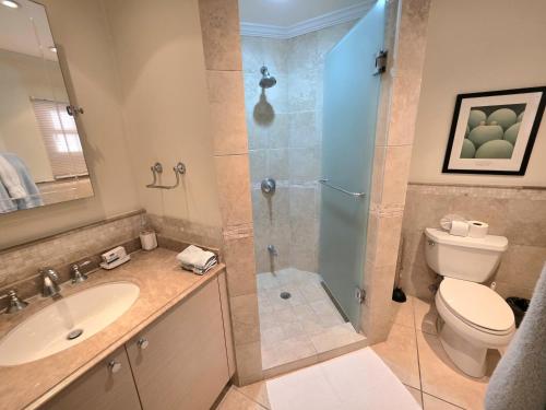 a bathroom with a shower and a toilet and a sink at 117 Sapphire Beach Condo in Christ Church
