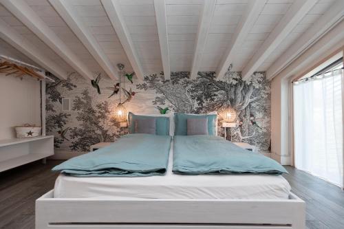 a bedroom with a bed and a wall mural at Biancaleo Homes in Affi