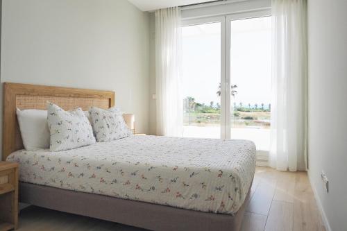 a bedroom with a bed and a large window at Penthouse duplex with jacuzzi, 5 min to beach in Chipiona