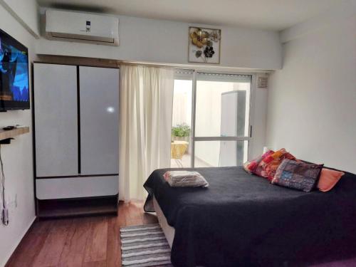 a bedroom with a bed and a large window at Diseñado para vos, a pasos de Bv Oroño con cochera opcional in Rosario