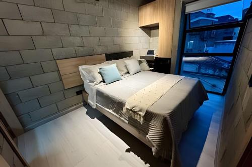 a bedroom with a bed in a brick wall at Our Home Granada in Cali