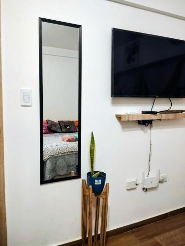 a mirror on a wall next to a bedroom at Diseñado para vos, a pasos de Bv Oroño con cochera opcional in Rosario