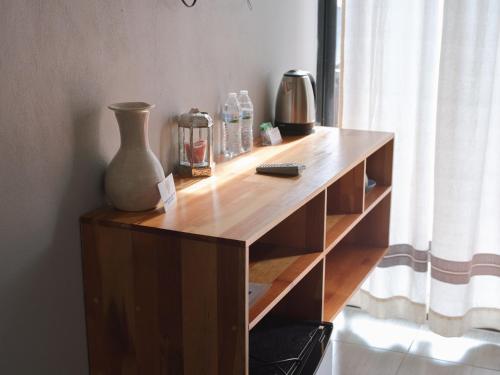 a wooden shelf with a vase and a remote control on it at Margarita in Oaxaca City