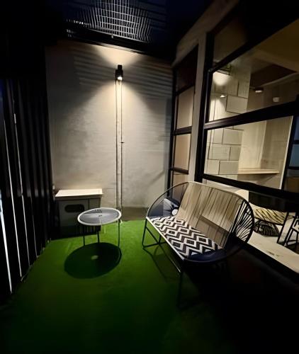 a room with a green floor and a table and chair at Our Home Granada in Cali