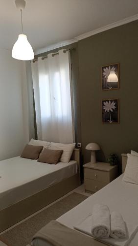 a bedroom with two beds and a window at Villa Dallas-Beach,Bike & Gym in Vourvourou