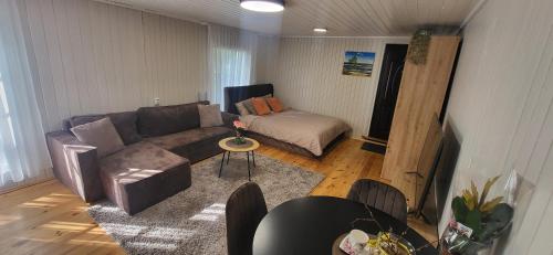a living room with a couch and a table at Sodyba pas Babą - Apartamentai "EGLYNAS" Šventoji in Palanga