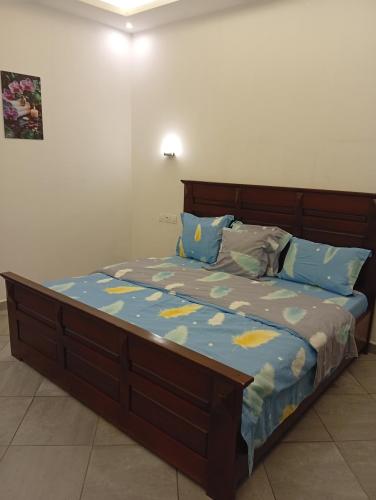 a bedroom with a bed with blue and yellow sheets at Résidence Prestige KGV Appt 304 in Douala