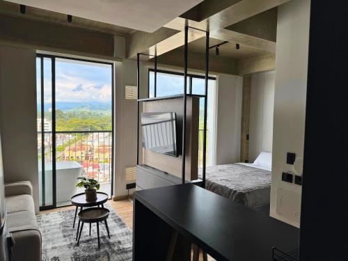 a bedroom with a bed and a balcony with a view at TokioLiving in Armenia