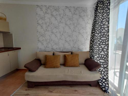 a couch sitting in a living room next to a window at Studio Marina Cape 89 in Aheloy