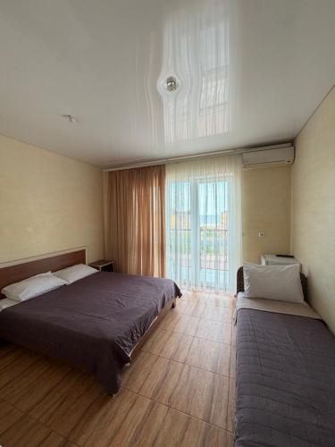 a bedroom with two beds and a large window at Sakura Hotel in Zatoka