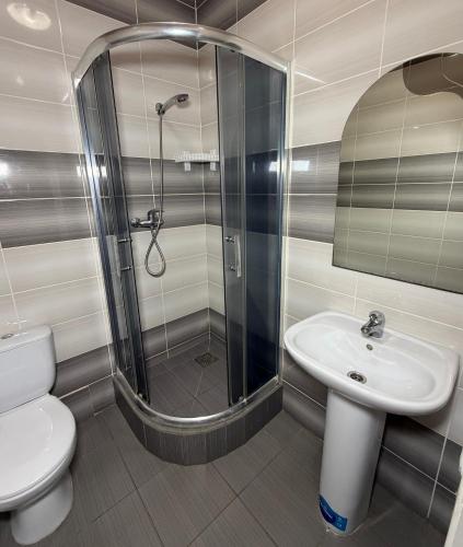 a bathroom with a shower and a toilet and a sink at Sakura Hotel in Zatoka