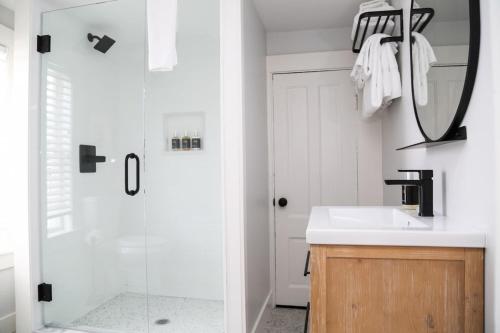 a bathroom with a shower and a sink and a mirror at Waterford Inn Provincetown in Provincetown