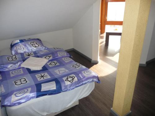 a bedroom with a bed with a blue comforter at Apartments Excalibur Despotovac - Kod upravnika in Despotovac