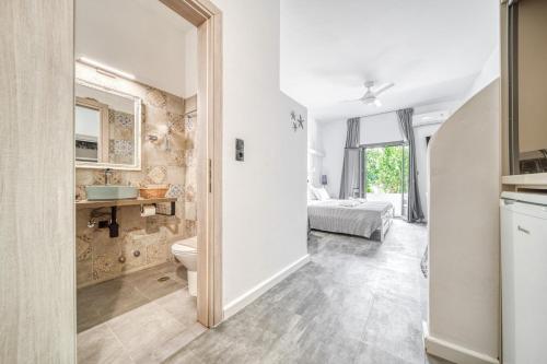 a bathroom with a toilet and a bedroom at Guesthouse Perdikouli in Aliki