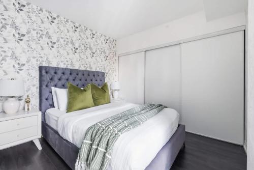 a bedroom with a large bed and a wall at Charming 2BR downtown condo with private patio in Toronto