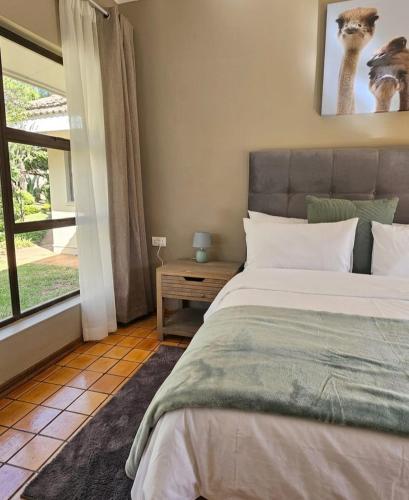 a bedroom with a bed and a window at Montgomery Highlands Estate in Harare