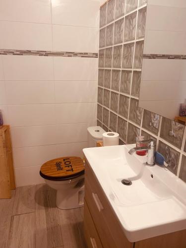 a bathroom with a wooden toilet and a sink at Cap Alizés in Petit-Canal