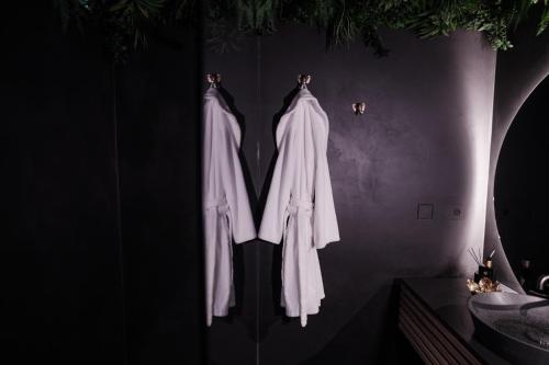 a group of white robe hanging on a wall at Maison Lillie in Zonnebeke