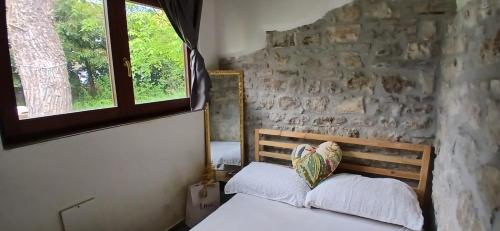 a bedroom with a bed and a stone wall at The Garden House in Boiano