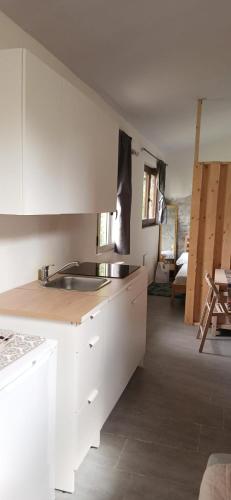 a kitchen with white cabinets and a sink at The Garden House in Boiano