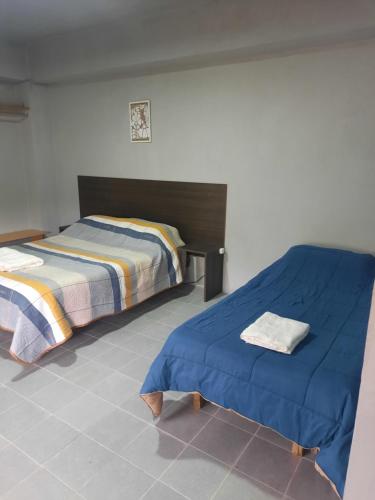 a bedroom with two beds and a tiled floor at Linda estadia 2 in San Juan