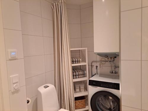 ein kleines Badezimmer mit einer Waschmaschine darin in der Unterkunft Nyrenoverad lägenhet med gratis parkering in Partille