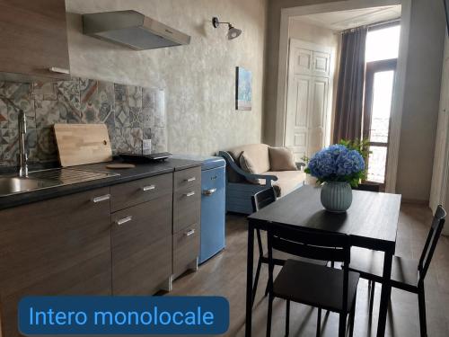 a kitchen and living room with a table and a kitchen and a couch at Chrilu house in Catania