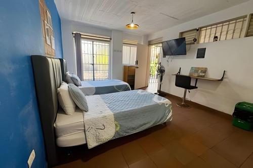 a bedroom with two beds and a television in it at Our Home San Antonio in Cali