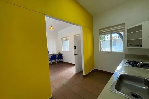 a kitchen with yellow walls and a kitchen with a sink at Our Home San Antonio in Cali