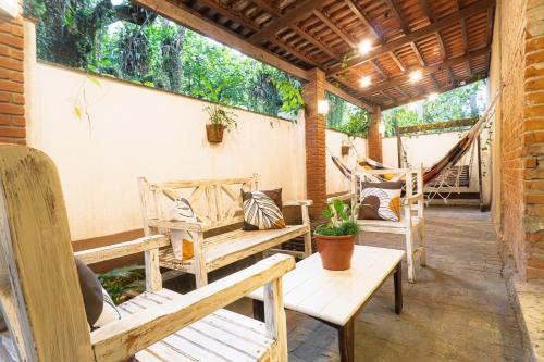 a porch with wooden benches and a hammock at Hotel Rio Guarujá - "Sua casa na praia" in Guarujá