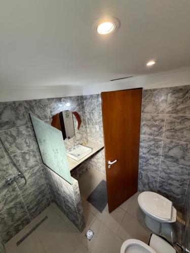 a bathroom with a toilet and a sink at Colibrí in Merlo