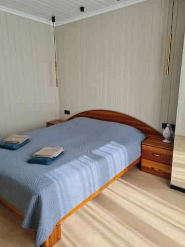 a bedroom with a bed with two towels on it at Apšuciema Birzīši in Apšuciems
