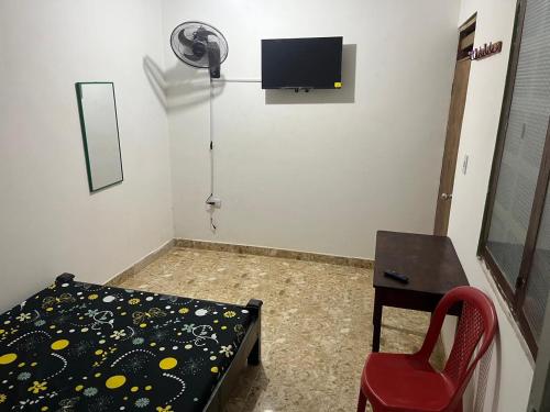 a room with a bed and a chair and a desk at Hotel Don Franco in Villagarzón