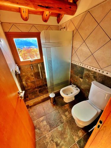 a small bathroom with a toilet and a window at Paraiso de Montaña in Villa Pehuenia