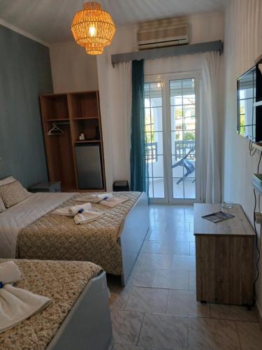 a hotel room with two beds and a balcony at Acheron rooms in Preveza