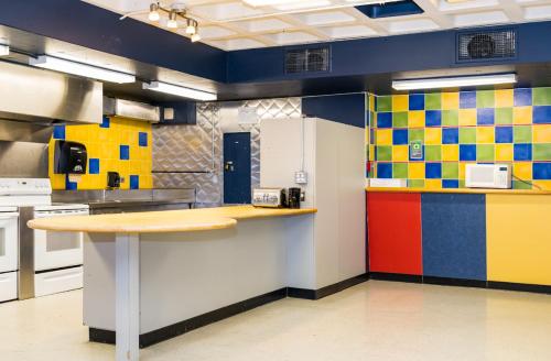 a large kitchen with colorful tiles on the walls at Résidences du Cégep de Rimouski in Rimouski