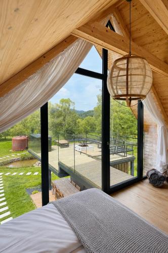 a bedroom with a bed and a large window at Krzywe Pearl Chalets in Krywe