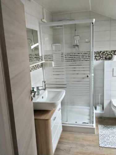 a white bathroom with a sink and a shower at Work & Stay Peine, Parkplatz, WLAN, Küche inkl in Peine