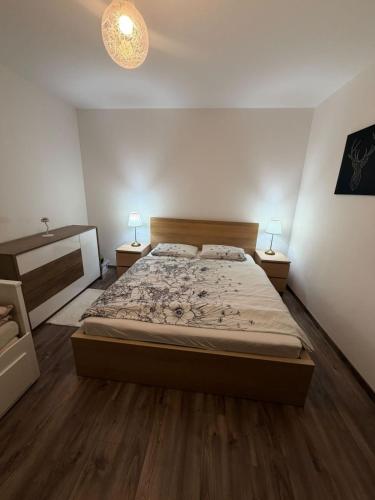 a bedroom with a bed and two lamps on two tables at Ubytovanie u Tomáša in Nesvady