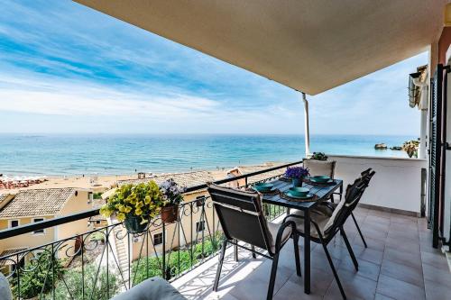 a balcony with a table and chairs and the ocean at Corfu Glyfada Beach Apartments in Glyfada