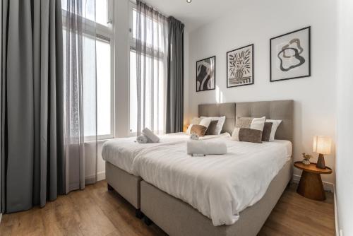 a bedroom with a large bed and a large window at Unique home near Tilburg center, uni & Efteling, in Tilburg