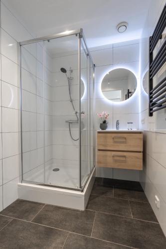 a bathroom with a shower with a sink and a mirror at Unique home near Tilburg center, uni & Efteling, in Tilburg