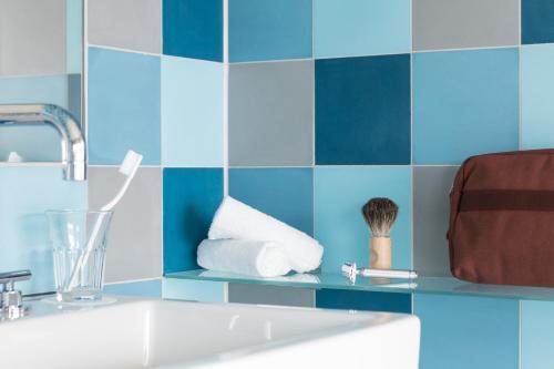 a bathroom with blue tiled walls and a sink at Placid Hotel Design & Lifestyle Zurich in Zürich