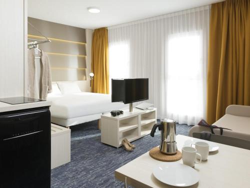 a hotel room with a bed and a tv at Ibis Styles Nivelles in Nivelles