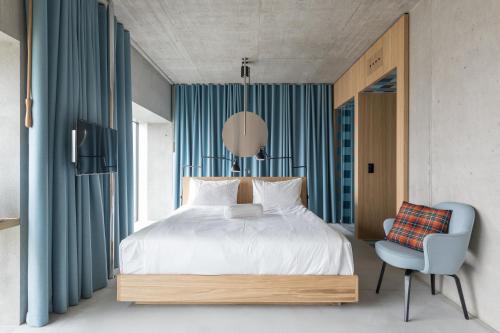 ein Schlafzimmer mit einem großen Bett und einem Stuhl in der Unterkunft Placid Hotel Design & Lifestyle Zurich in Zürich